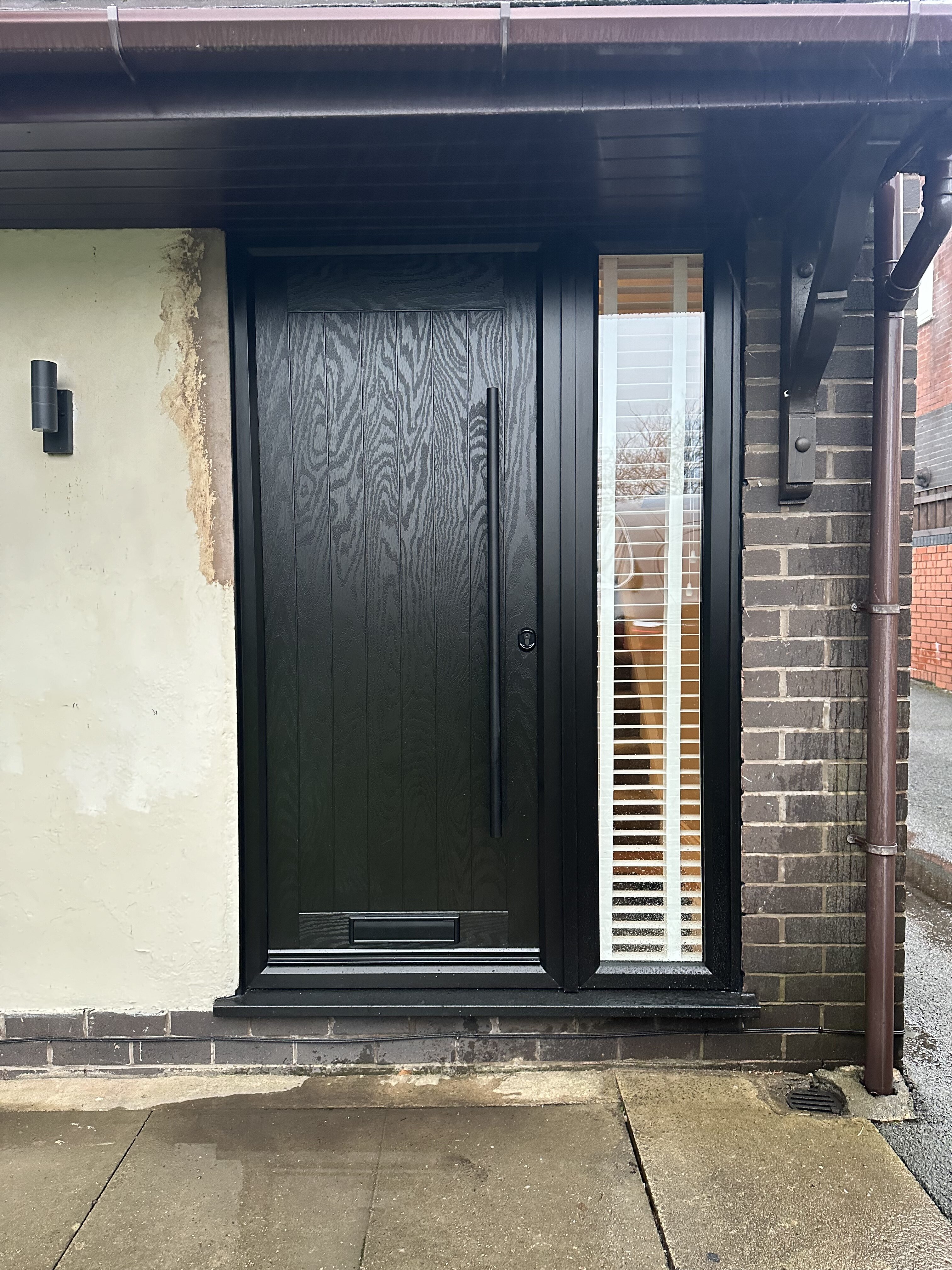 Solid no glass modern front composite door with all black bar handle and black hardware and clear glass