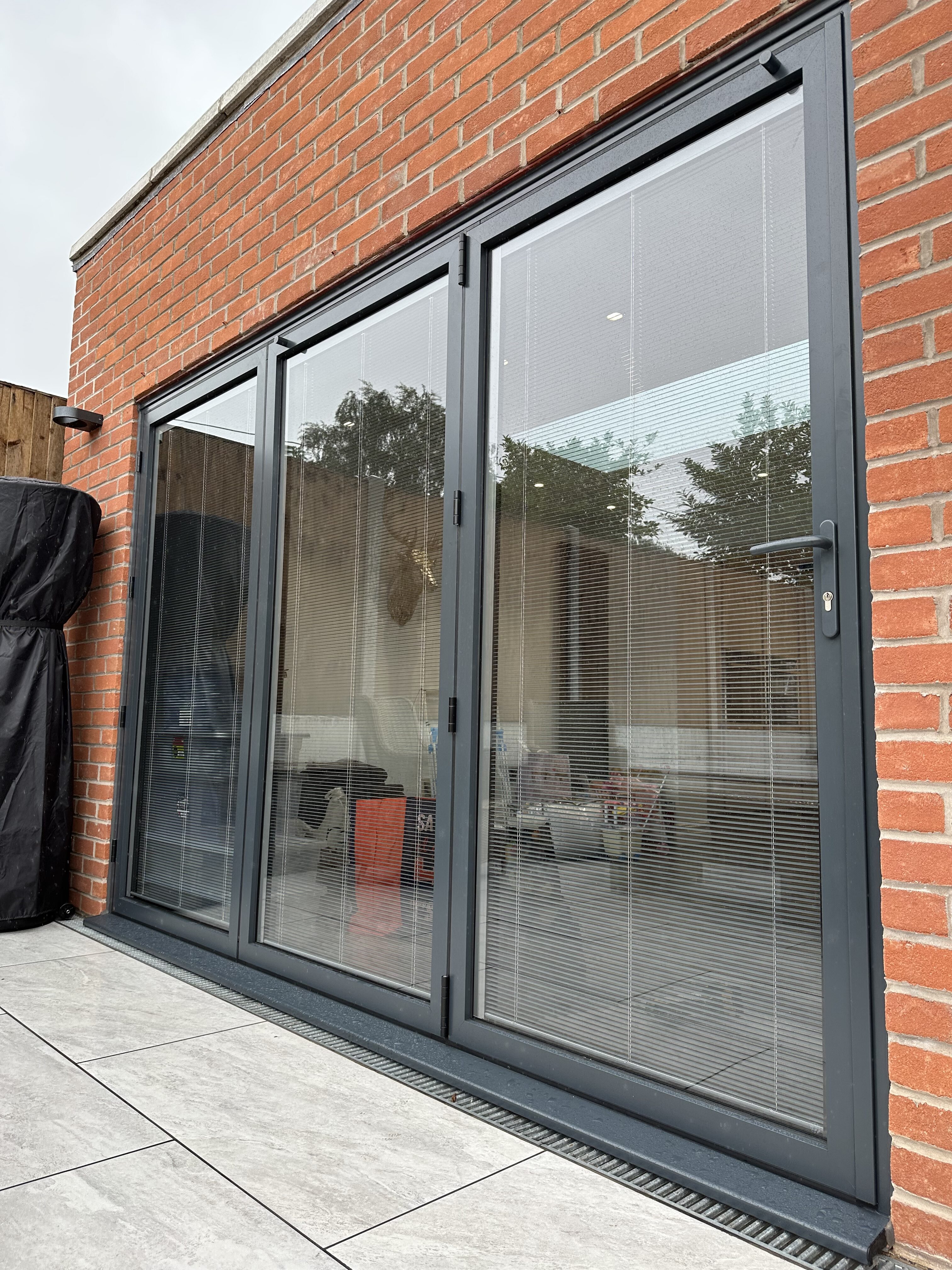 grey 3 pain aluminium bi folding doors with integral blinds